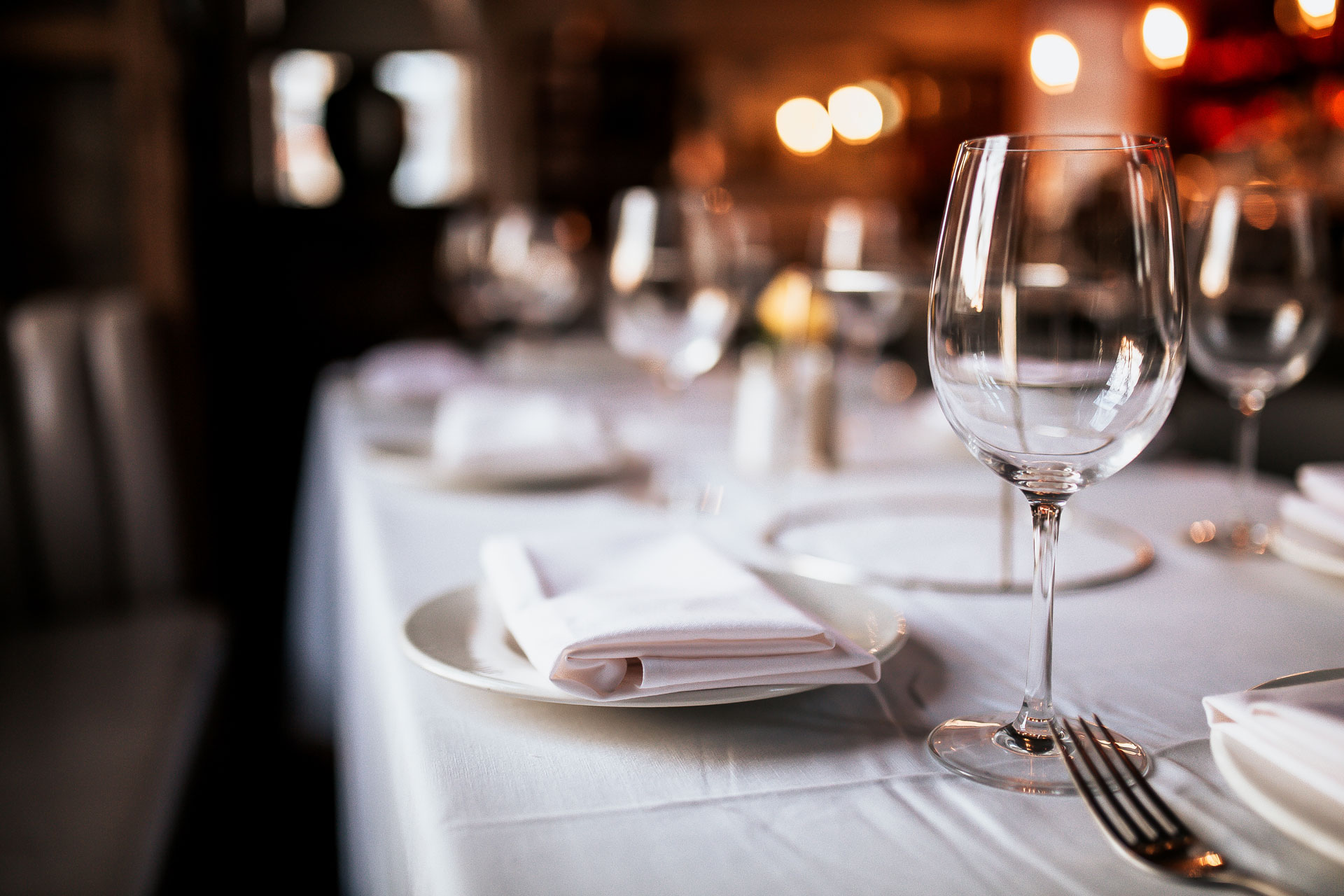 restaurant dining table set with plates and glasses
